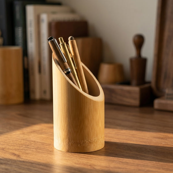 Bamboo Pen Stand PS-1 holding pens on a warm walnut desk, diagonal cut visible