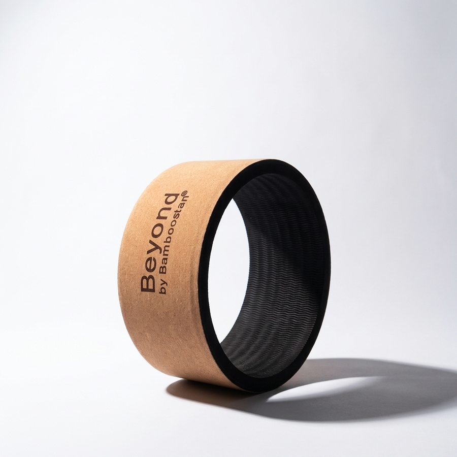 Cork yoga wheel tilted on its side, showing the 'Beyond by Bamboostan' branding, on a plain background.